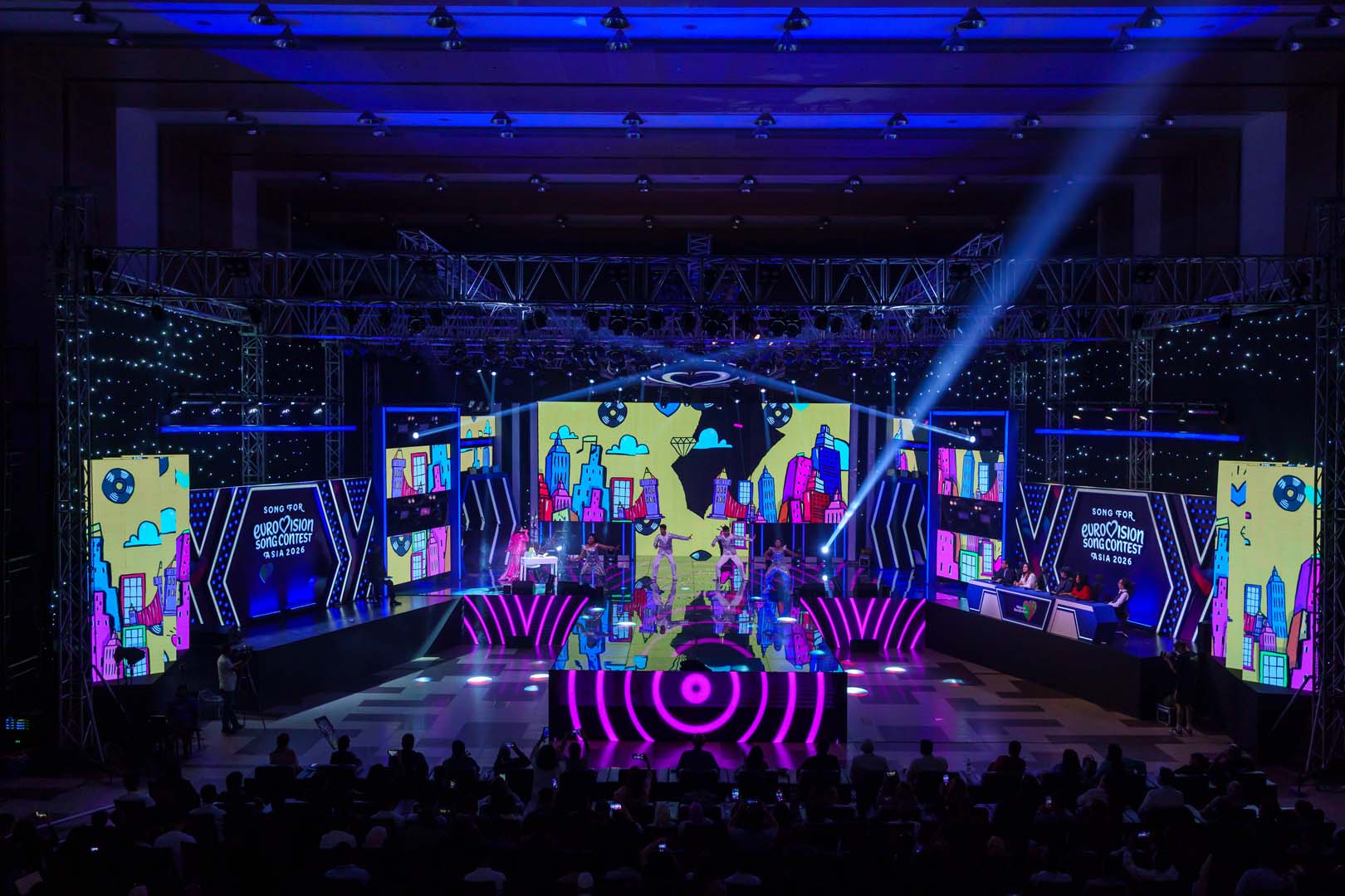 Yellow and pink comic-city LED visuals with a DJ stage