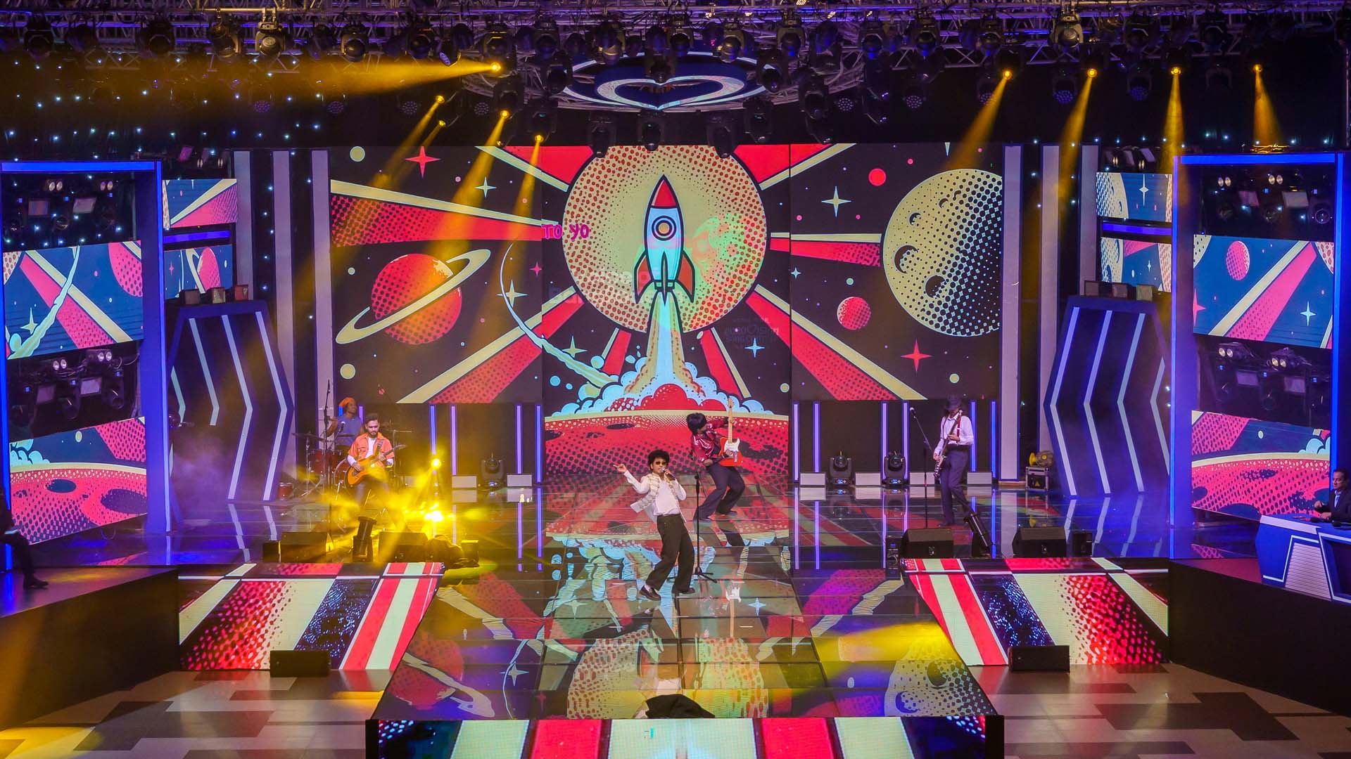 Retro comic-style rocket LED visuals with performers on stage