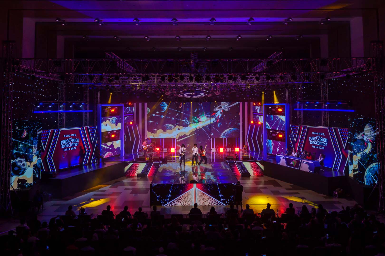 Space and planets comic-style LED visuals with a band performing